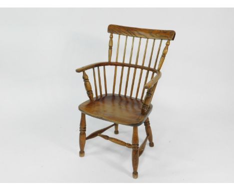 A 19thC oak and elm comb back Windsor chair, possibly West Country, with solid saddle seat, raised on turned legs united by a