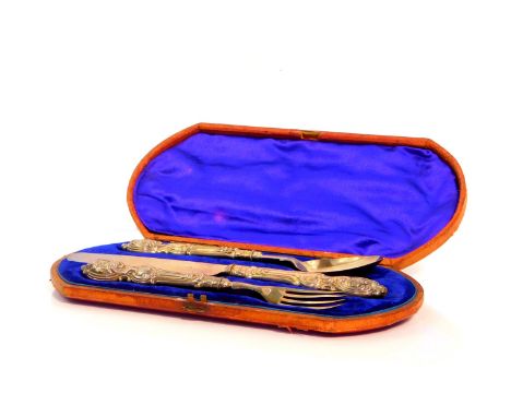 A Victorian silver three piece knife fork and spoon set, with ornate foliate scroll embossed handles, cased, Birmingham 1854,