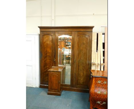 A Victorian oak compactum wardrobe, the outset pediment over a central door, inset domed bevelled glass, opening to reveal fo