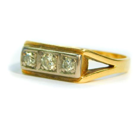 A diamond three stone ring, in a rectangular two colour setting, approximately 1/4 carat, size Q, stamped 18ct, 6.1g.