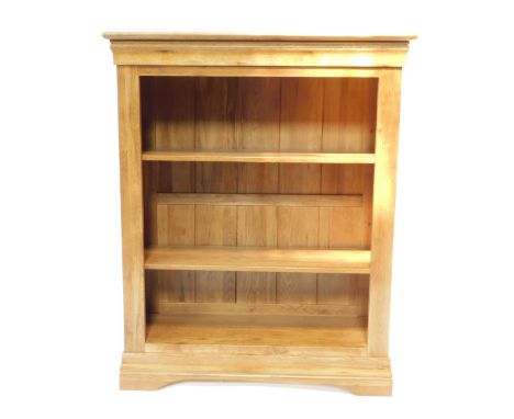 An oak open bookcase, fitted with two adjustable shelves, having a panelled and moulded top and on bracket feet, 109cm H, 89c