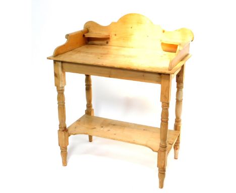 A Victorian style pine washstand, with shaped splash back and scrolling sides to the top, and with a pot shelf below, on turn