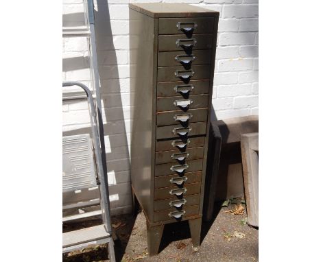 A green painted metal card filing cabinet, of fifteen drawers, raised on tapering bracket feet, 121cm H, 28cm W, 41cm D.