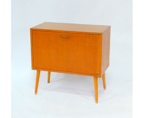 A 1950's oak record cabinet, the drop down front opening to reveal five recesses, raised on turned outswept legs, 67.5cm high