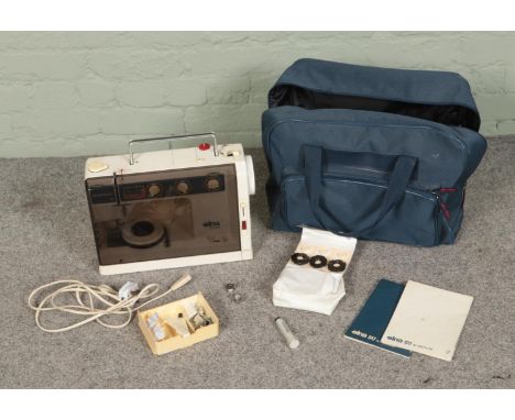 An Elna SU Air Electronic sewing machine with carry case, instruction manual and small collection of accessories.  