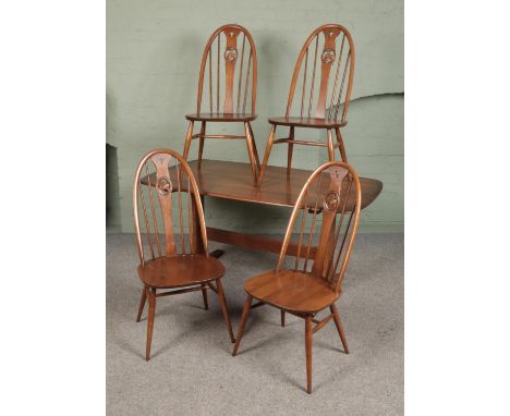 An Ercol dining table with four quaker swan back chairs.  