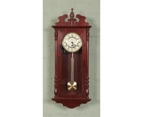 A vintage German Hermle cased wall clock featuring Roman numeral dial and Westminster chime.  