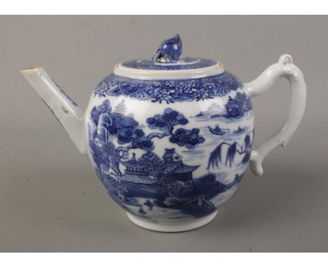 A 19th century bullet shape teapot with blue and white transfer print and lotus flower bud finial. Height 13cm.  Firing crack