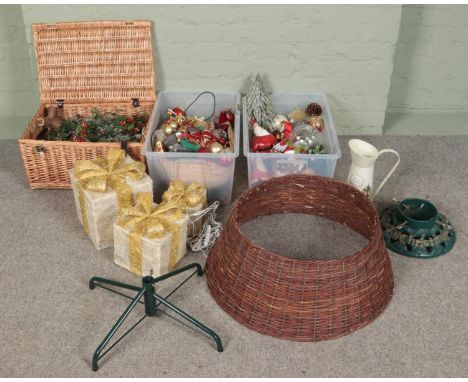 Three boxes of Christmas decorations. Includes baubles, cast iron tree stand, graduated light up presents, etc.  