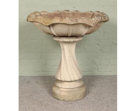 A very large birdbath/planter on twisted pedestal base and flared top. Height: 91cm, Width: 70cm.  Cracks to bowl.