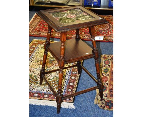 An oak aesthetic side table, the moulded square top with tiled insert, raised on splayed block and turned legs, united by she