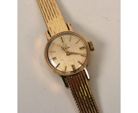 A 14ct gold lady's Omega wristwatch, the gold coloured dial with baton numerals, inscribed 'E.M.A.D' to underside, in origina