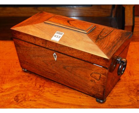 A Regency rosewood tea caddy, of sarcophagus shape, with hinged lid enclosing fitted compartments and mixing bowl, with ring 