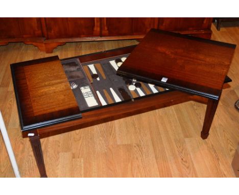 A modern games table, the pull up flap enclosing backgammon set, fitted drawers with playing cards, dominoes and chess pieces