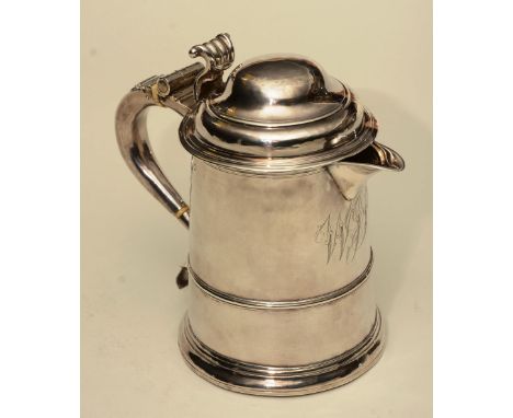 A silver water jug, marks worn, the turned lid with scroll handle, over shallow spout and tapering turned trunk, on plinth ba