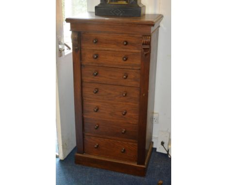 An oak Wellington chest, the seven graduated drawers with turned wood handles, raised on plinth base, 120cm high x 62cm wide 