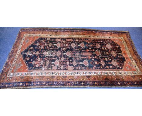 An antique Kurdish carpet, with urn and diamond design, over black ground, spandrels and tripe border, 275 x 157cm