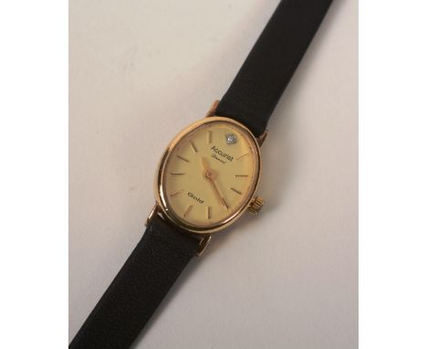 A 9ct gold 'Accurist Diamond' lady's wristwatch, the oval champagne dial with gold baton numerals, on black leather strap, wi