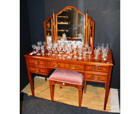 A modern yewwood dressing table, with central drawer flanked by two smaller drawers, raised on tapering supports, 77cm high x