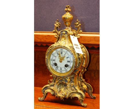 A French brass mantle clock, by Comptoir General Bol Poissonniere, Paris, mounted by urn finial, circular face, Arabic & Roma