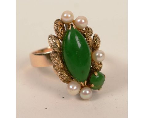 A 14ct gold jade and pearl ring, the foliate embossed crown set with large central marquis shaped jade, flanked by five pearl