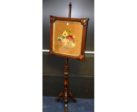 A Victorian mahogany pole screen, with glazed floral adjustable embroidered screen, raised on turned column and carved tripod