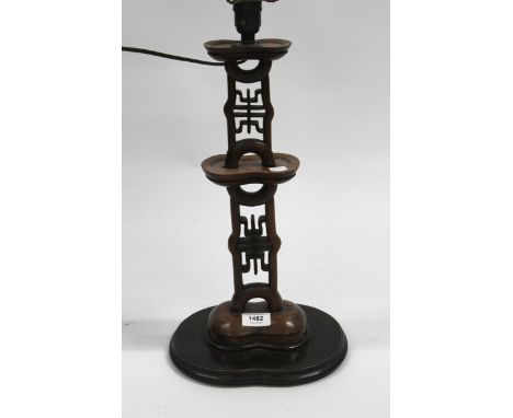 Chinese carved hardwood table lamp on a shaped base, 43cm high excluding shade and fitting