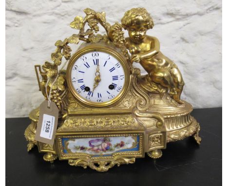 19th Century French ormolu mantel clock, the circular enamel dial with Arabic and Roman numerals, the case with bacchanalian 