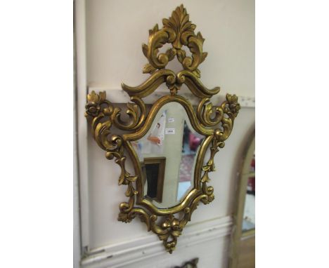 20th Century carved and gilded cartouche wall mirror with pierced floral and scroll design frame enclosing a bevelled plate, 