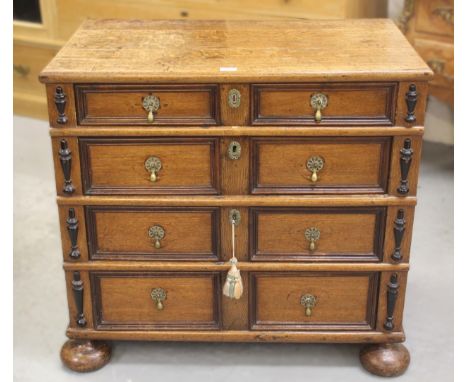 Small late 17th / early 18th Century oak moulded front chest, the plank top above four graduated drawers with brass drop hand