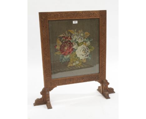 Early 20th Century carved oak firescreen inset with a needlepoint floral panel, 73cm wide