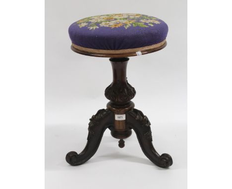 Victorian rosewood circular adjustable seat piano stool with a woolwork top, raised on carved baluster column and tripod supp