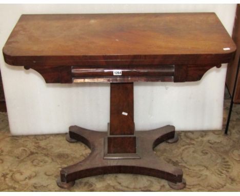 A Victorian mahogany fold over top card table with moulded frieze over, raised on a central square tapered and stepped column