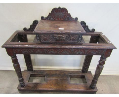 A Victorian carved oak two divisional umbrella/stick stand with central raised box section incorporating a frieze drawer with