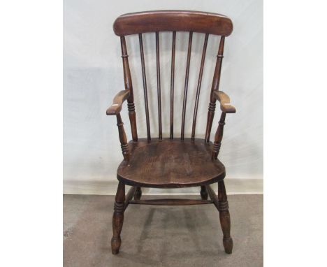 A Windsor stained elm and beechwood stick back armchair with saddle shaped seat on turned supports and stretchers