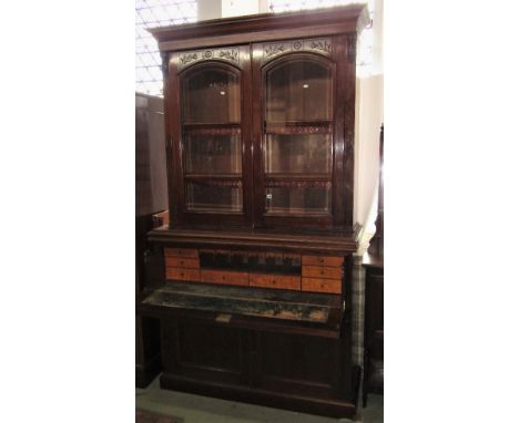 A Victorian mahogany secretaire bookcase, the upper recessed section enclosed by a pair of arched bevelled edge glazed panell