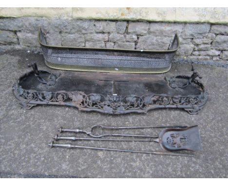 A Victorian cast iron fender with scrolling pierced fruiting vine rail with central lions mask, together with one other and a