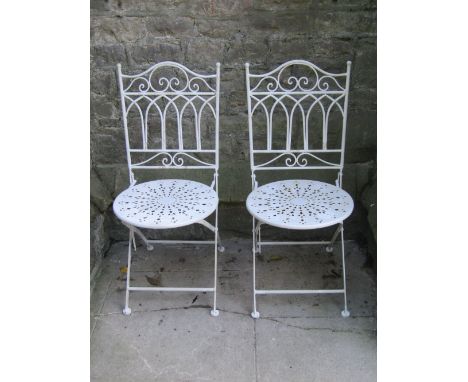A pair of cast iron bench ends with decorative pierced foliate detail and green painted finish, together with a pair of light