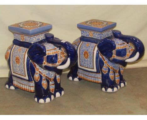 A pair of blue glazed ceramic garden seats in the form of standing elephants wearing decorative ceremonial head dress 