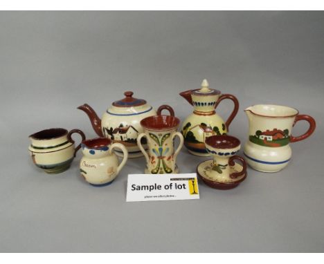 An extensive collection of Torquay wares including teapot, coffee pot, hot water jugs, various other jugs including puzzle ju