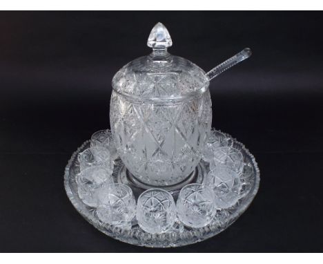 A good quality cut glass lidded punch bowl with ladle and a collection of cups, all on a cut glass tray/stand