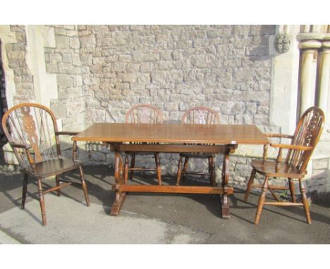 An oak refectory table, the rectangular top raised on a pair of lyre shaped supports united by a pegged rail together with ei