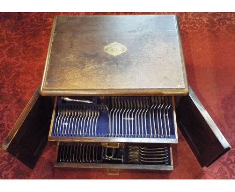 19th century canteen of beaded flatware, the oak box with twin doors enclosing four graduated drawers fitted with recessed br