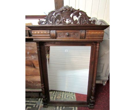 A late 19th century wall mirror with rectangular bevelled edge mirror plate within an oak frame, with carved detail, fluted c