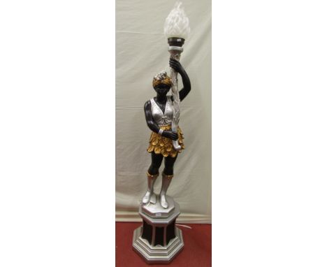 A plaster lamp standard in the form of a character supporting aloft a cornucopia, with glass framed shade, raised on an octag