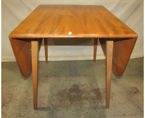 An Ercol light elm drop leaf dining table with moulded outline raised on splayed legs together with a pair of further Ercol h