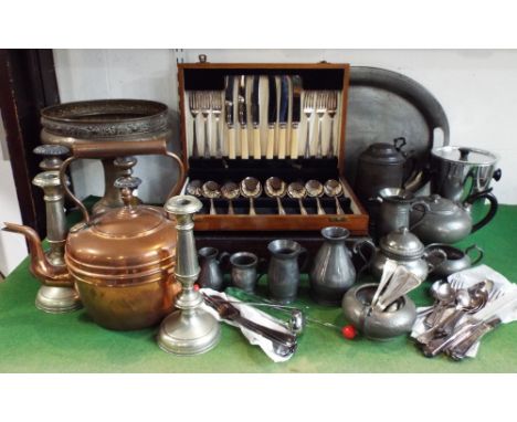 A mixed collection of metal ware to include two canteens of cutlery, an Arts &amp; Crafts brass tazza, a pewter tea service, 
