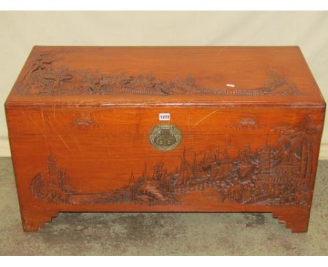An Eastern camphor wood with hinged lid and profusely carved detail, raised on stepped bracket feet