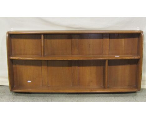 An Ercol medium to light elm wall hanging plate rack with segmented shelves and moulded outline, 107cm long x 12cm wide x 50c