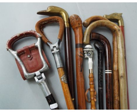 A collection of walking sticks and canes to include an interesting carved eastern hardwood cane with brass inlay and bands, a